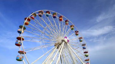 Dönme dolap lunaparkta mavi gökyüzü arka planıyla