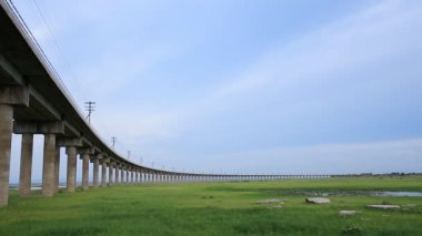 Pasuk Nehri Barajı, Lopburi, Tayland 'da tren çim çayırını geçiyor.