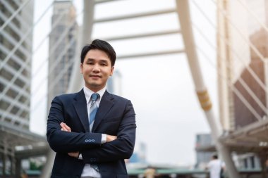 Takım elbiseli bir iş adamı, şehirde çapraz çizgili ve düşünüyor.