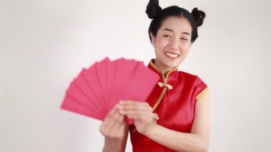 Kadınlar Cheongsam giyer ve mutlu Çin Yeni Yılı kavramında kırmızı zarf tutar. 