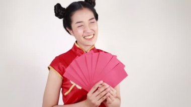 Kadınlar Cheongsam giyer ve mutlu Çin Yeni Yılı kavramında kırmızı zarf tutar. 