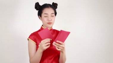 Kadınlar Cheongsam giyer ve mutlu Çin Yeni Yılı kavramında kırmızı zarf sayar. 