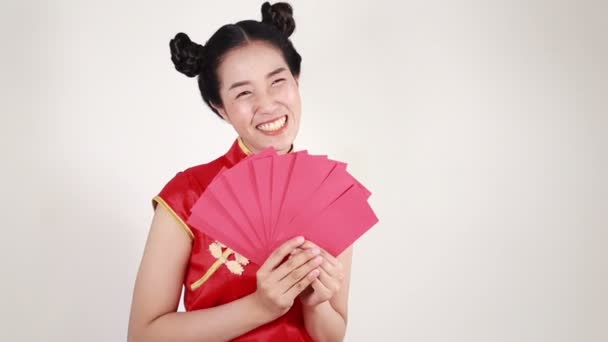 女性は幸せな中国の新年をコンセプトにチョンサムを着用し 赤い封筒を保持 — ストック動画