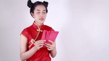 Kadınlar Cheongsam giyer ve mutlu Çin Yeni Yılı kavramında kırmızı zarf sayar. 
