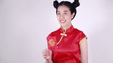 Kadınlar Cheongsam giyer ve mutlu Çin Yeni Yılı kavramında kırmızı zarf açarlar. 