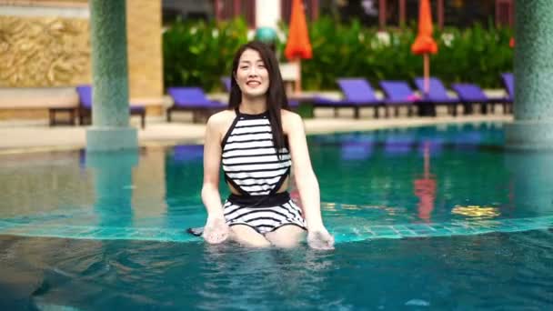 水泳プールで若い美しい女性が水を撒き散らし — ストック動画