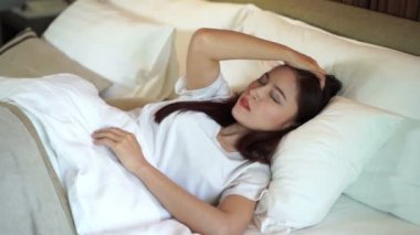 Yatakta uykusuz bir kadının yavaş çekimi. 