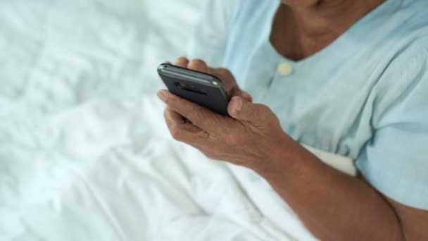 Senior Vrouw Met Behulp Van Mobiele Telefoon Een Bed — Stockvideo