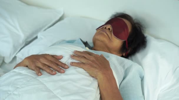 寝室のベッドでアイマスクをした年配の女性は — ストック動画