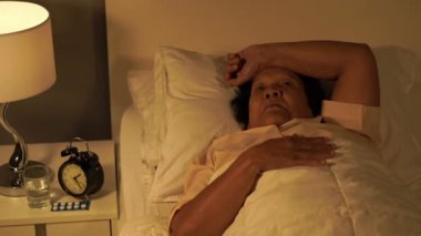 Uykusuzluk çeken yaşlı kadın geceleri yatakta uyumaya çalışıyor.