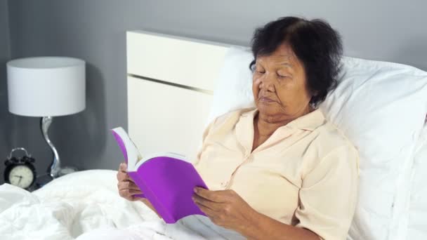 Oude Vrouw Leest Een Boek Bed Slaapkamer — Stockvideo
