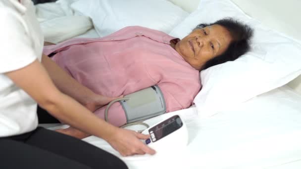 Enfermeira Verificando Pressão Arterial Uma Mulher Idosa Cama — Vídeo de Stock