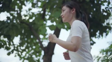 Parkta koşan genç bir kadının ağır çekimde