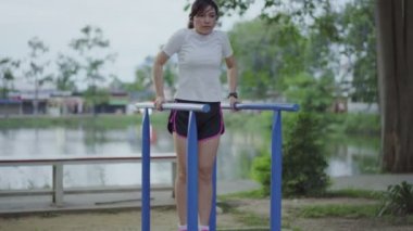 Kadınlar parktaki fitness makinesinde oynarlar.