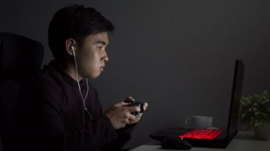 Stresli genç adam oyun oynamak için joystick kullanıyor