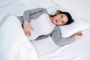 Hamile kadın yatakta uyuyor.