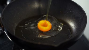 Yavaş çekimde yumurta çatırdatan eller tavaya düşüyor.