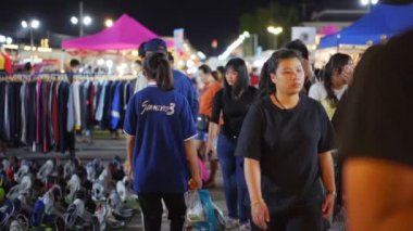 NAKHON RATCHASIMA, THAILAND - 28 SEP 2018: Nakhon Ratchasima 'nın en popüler gece marketlerinden biri olan Save-One pazarında yürüyen ve alışveriş yapan kimliği belirsiz kişilerin yavaş çekim. Turistler alışverişi sever, gece pazarı her gün açıktır..