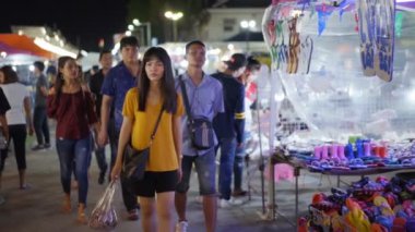 NAKHON RATCHASIMA, THAILAND - 28 SEP 2018: Nakhon Ratchasima 'nın en popüler gece marketlerinden biri olan Save-One pazarında yürüyen ve alışveriş yapan kimliği belirsiz kişilerin yavaş çekim. Turistler alışverişi sever, gece pazarı her gün açıktır..