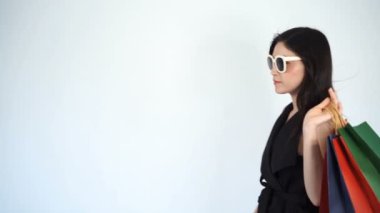 Güneş gözlüğü takan ve yürüyen alışveriş yapan kadınların yavaş çekimleri. 