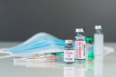 Coronavirus covid-19 aşı şişeleri ve şırınga enjeksiyon ilacı ve tıbbi maske