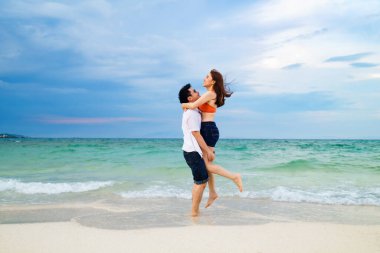 Genç çift Koh MunNork Adası, Rayong, Tayland sahillerinde toplanıp kucaklaşıyorlar.