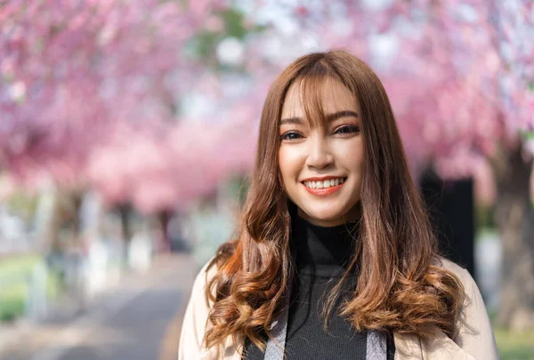 公園で桜や桜の花を見ている若い女性旅行者 — ストック写真