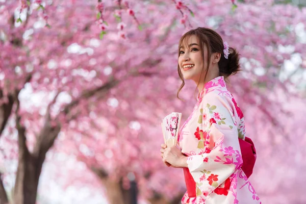 Žena Yukata Kimono Šaty Drží Skládací Ventilátor Vypadá Sakura Květ — Stock fotografie