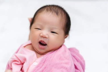 Neşeli yeni doğmuş bebek annesinin kollarında