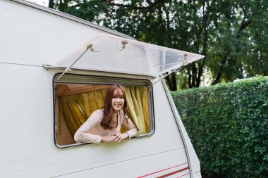 Karavan karavanının vitrinindeki mutlu genç kadın.