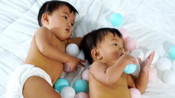 Cheerful Twin Babies Playing Color Ball Bed — Stock Video