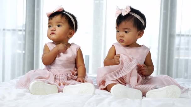 Two Twin Babies Pink Dress Bed One Looking One Crying — Stock Video