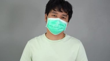 Tıbbi maskeli adam (cerrahi maske) alkol jeli, koronavirüs koruması kullanıyor.