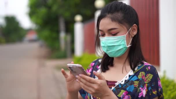 Νεαρή Γυναίκα Ιατρική Μάσκα Χειρουργική Μάσκα Χρησιμοποιώντας Ένα Smartphone Coronavirus — Αρχείο Βίντεο