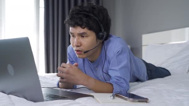 Estresado Hombre Negocios Usar Auriculares Videollamadas Ordenador Portátil Una Cama — Vídeo de stock