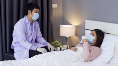 Doktor yatakta hasta bir kadınla konuşuyor ve danışmanlık yapıyor, insanlar koronavirüsten korunmak için tıbbi maske takıyor olmalı (covid-19).