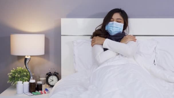 風邪やウイルス病や熱を感じる医療用マスクの病気の女性ベッドで コロナウイルス Covid パンデミックの概念 — ストック動画
