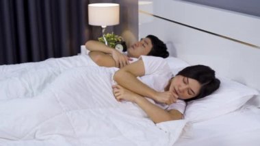 Kocası evde yatağında yatarken hasta bir kadın öksürüyor ve baş ağrısı çekiyor.