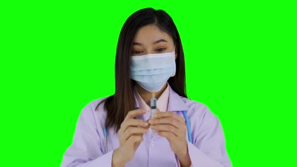 Female Doctor Medical Mask Holding Coronavirus Vaccine Syringe Green Screen — Stock Video
