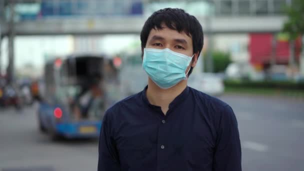 都会の路上でコロナウイルス Covid のパンデミックを予防するために医療マスクをした若いアジア人男性 新しい概念は — ストック動画