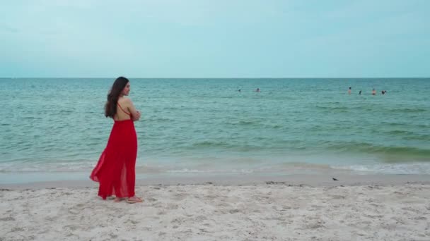 Szczęśliwa Kobieta Czerwonej Sukience Stojąca Ramionami Skrzyżowanymi Plaży Morskiej Wiatrem — Wideo stockowe