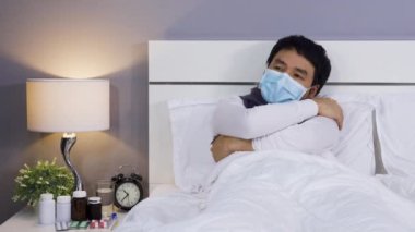 Tıbbi maske takan hasta adam hasta ve yatakta virüs hastalığı ve ateş, koronavirüs (covid-19) pandemik konsept.
