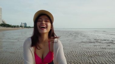 Yavaş çekimde bikinili neşeli kadın deniz sahilinde eğleniyor.