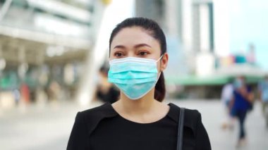 Şehirde Coronavirus (covid-19) salgınından korunmak için tıbbi maske takan iş kadını