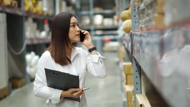 Młoda Kobieta Pracownik Rozmawia Przez Telefon Komórkowy Przytrzymując Schowek Sprawdzania — Wideo stockowe