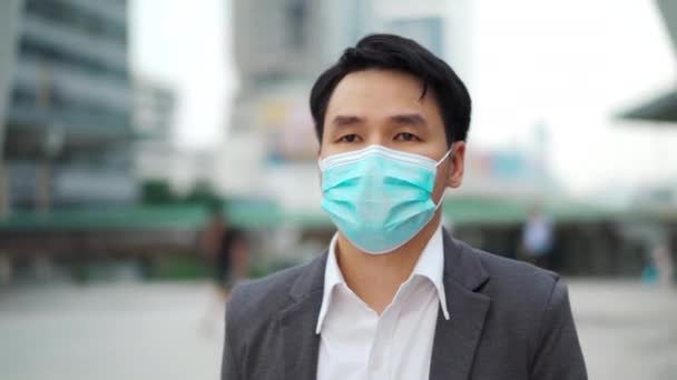 市内のコロナウイルス Covid パンデミック時に医療マスクをして歩くビジネスマン — ストック動画