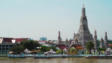 panning shot of Wat Arun Temple with Chao Phraya river in Bangkok, Thailand