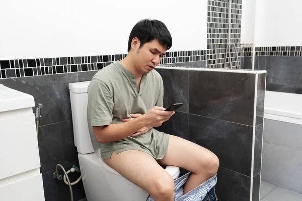 Hombre Infeliz Con Dolor Estómago Usando Teléfono Inteligente Sentado Inodoro — Foto de Stock