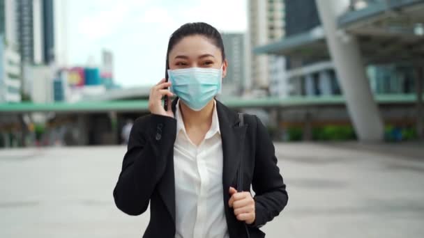 Mujer Negocios Caminando Con Teléfono Inteligente Usando Máscara Médica Para Video de stock