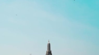panning shot of Wat Arun Temple with Chao Phraya river in Bangkok, Thailand